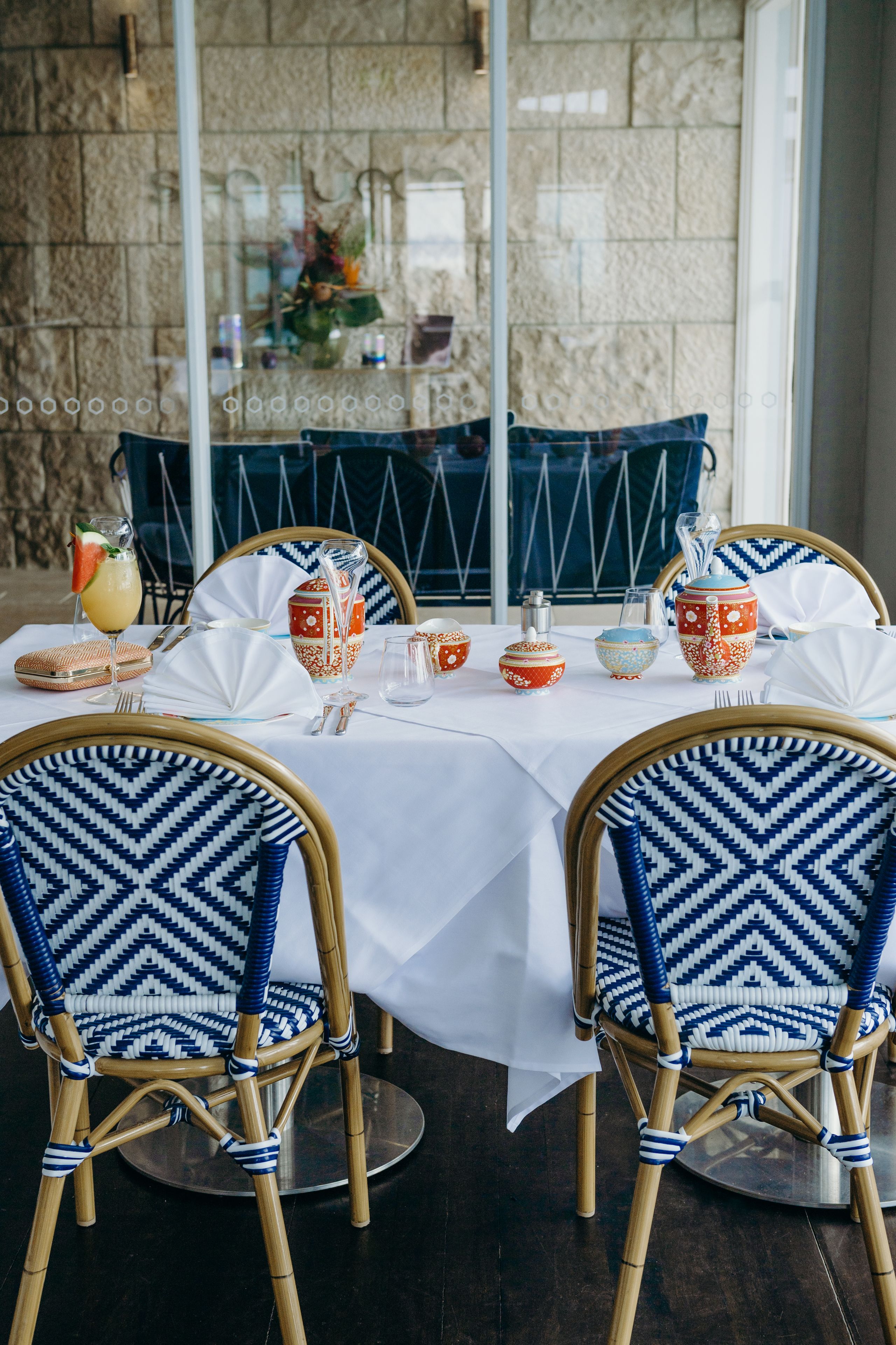 A dining area with a white tablecloth, blue and white patterned chairs, and decorative items.