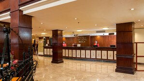 A hotel reception area with a wooden reception desk, a cash register, and a sign that reads "Bayview Park Hotel Manila." - Bayview Park Hotel Manila (Manila)