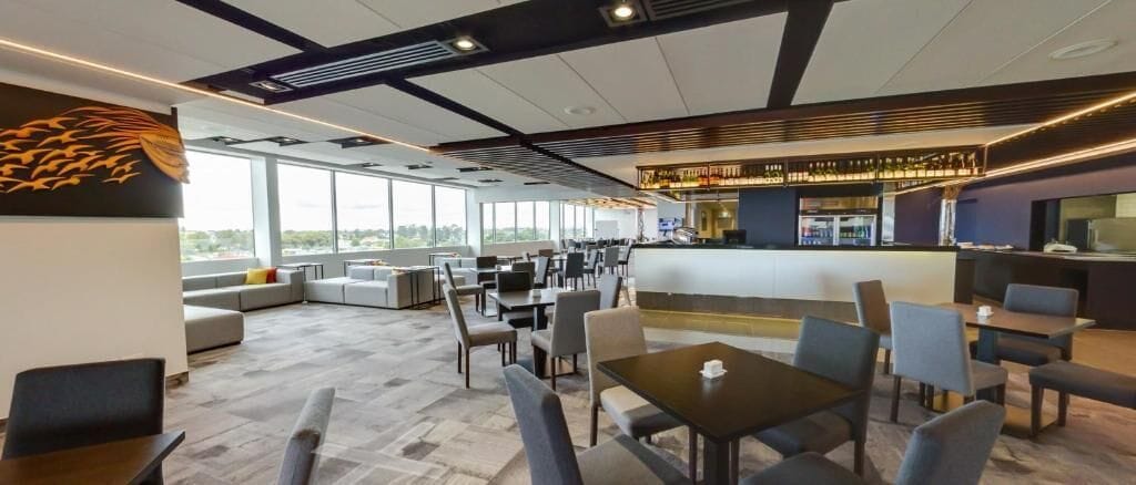 Un espace lounge moderne, doté de différents types de sièges, d’un bar et de grandes fenêtres offrant une vue panoramique.