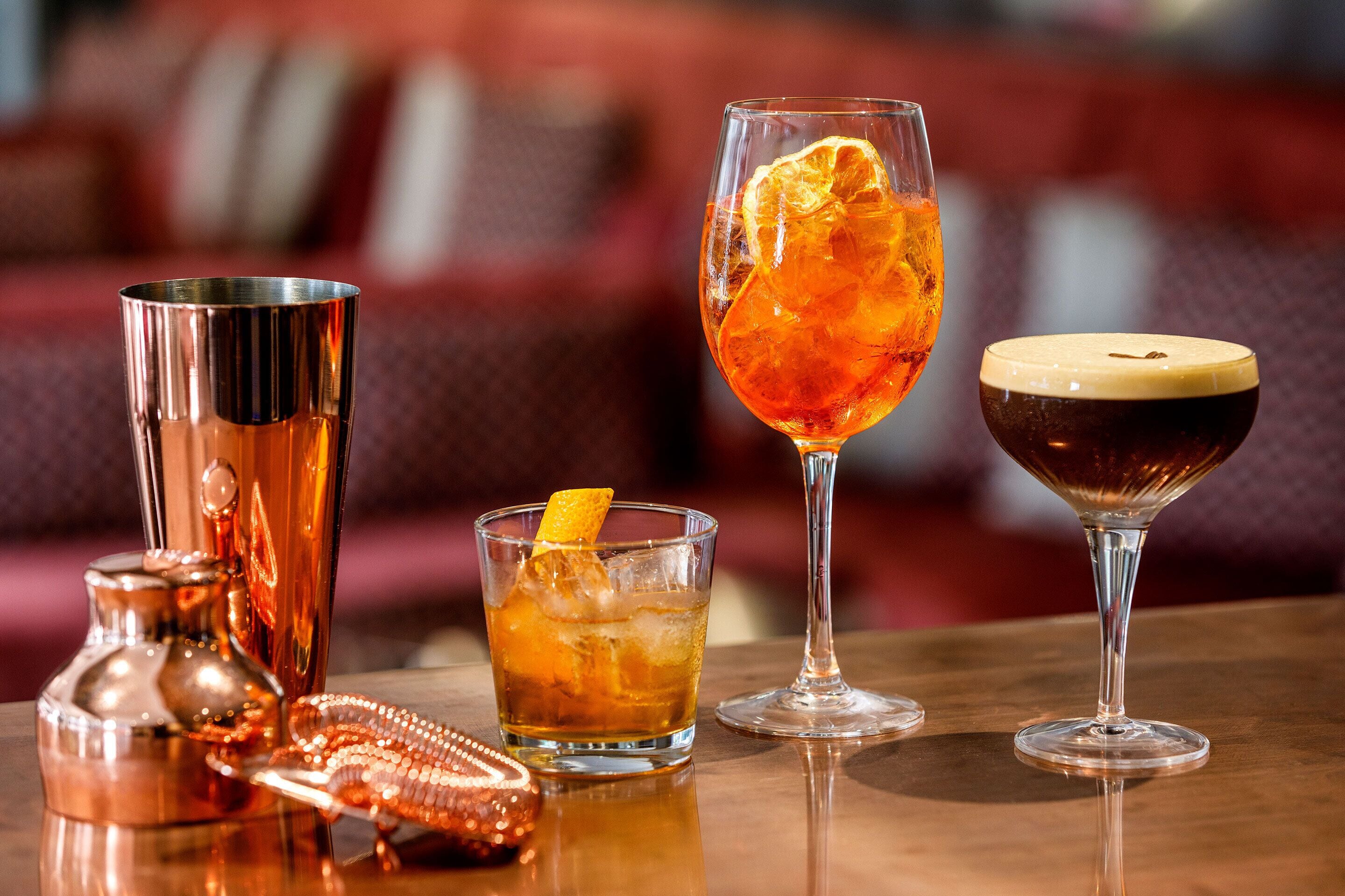 A bar setting with various glasses and a cocktail shaker.
