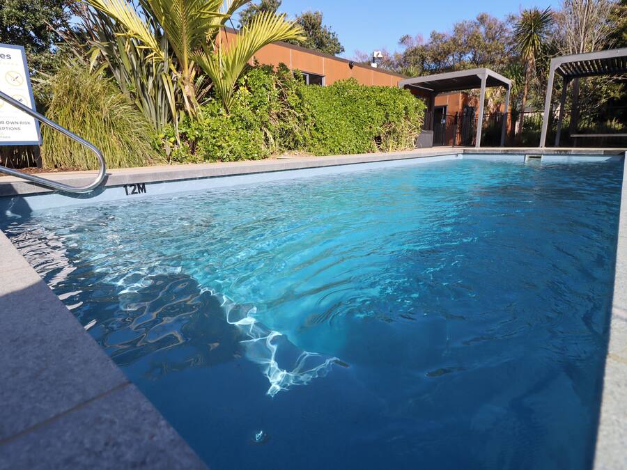 A swimming pool with a sign indicating a 12-meter depth.