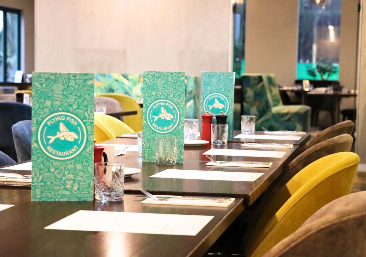 A conference table with green placemats and a logo for Flying Fish Restaurant.