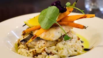 Un plato de comida con pescado, arroz y verduras.