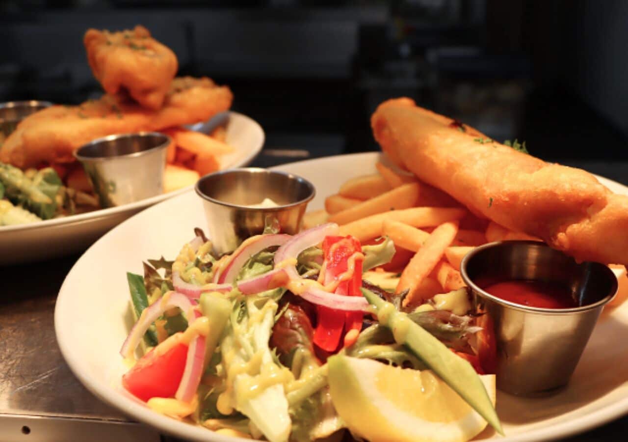A plate of food including a salad, fries, and bread.