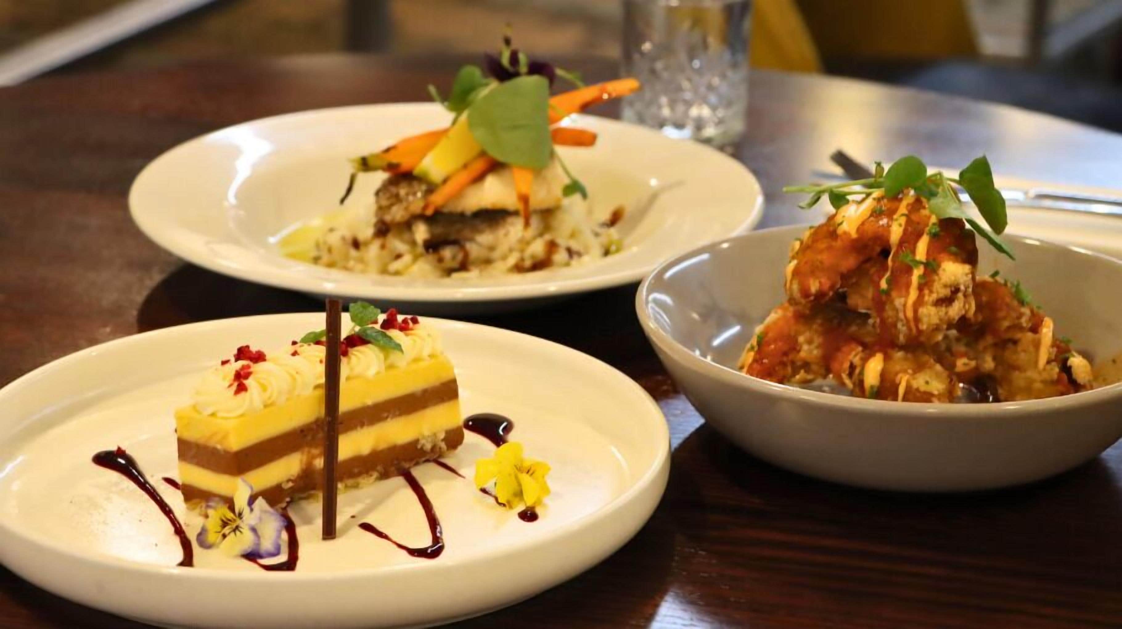 Three plates of food on a table.
