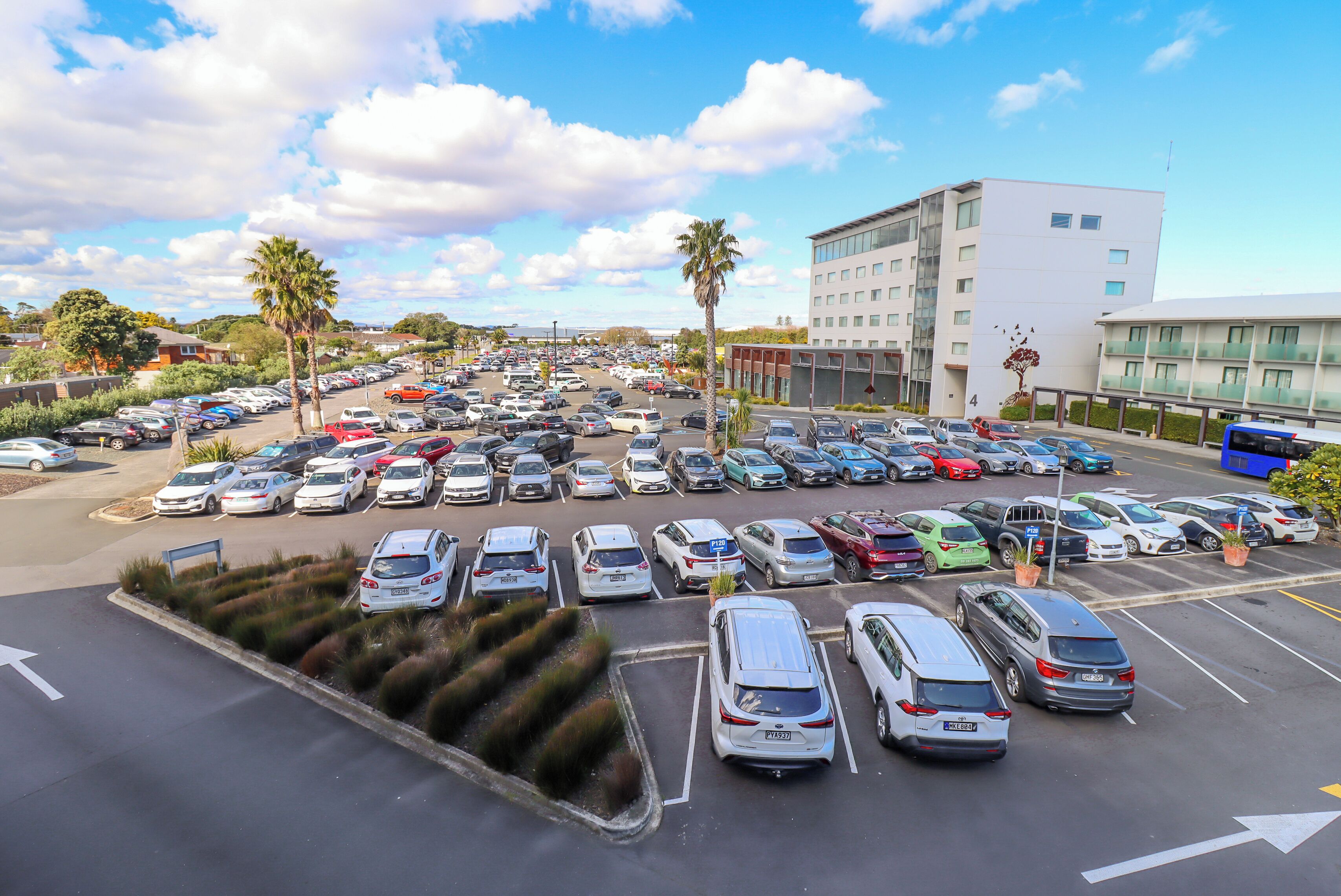 A parking lot with multiple cars and a building in the background.