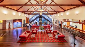 A spacious lobby with high ceilings, wooden beams, and a large chandelier.