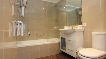 Une salle de bain moderne avec une douche à parois de verre, une baignoire blanche et des toilettes.