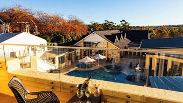 Relax by the pool with a hot tub and lounge chairs on a wooden deck.