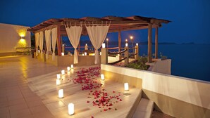An outdoor terrace with a pergola, candles, and rose petals. - Hotel Punta Serena & Resorts- Couples Only (Tenacatita)