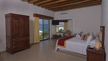 Quarto com cama grande, guarda-roupa de madeira e televisão na parede.
