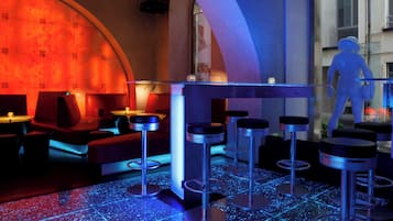 Un área de bar con taburetes y un suelo iluminado con neón.