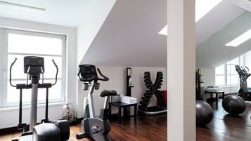 A home gym with exercise equipment, a large window, and a mirror.