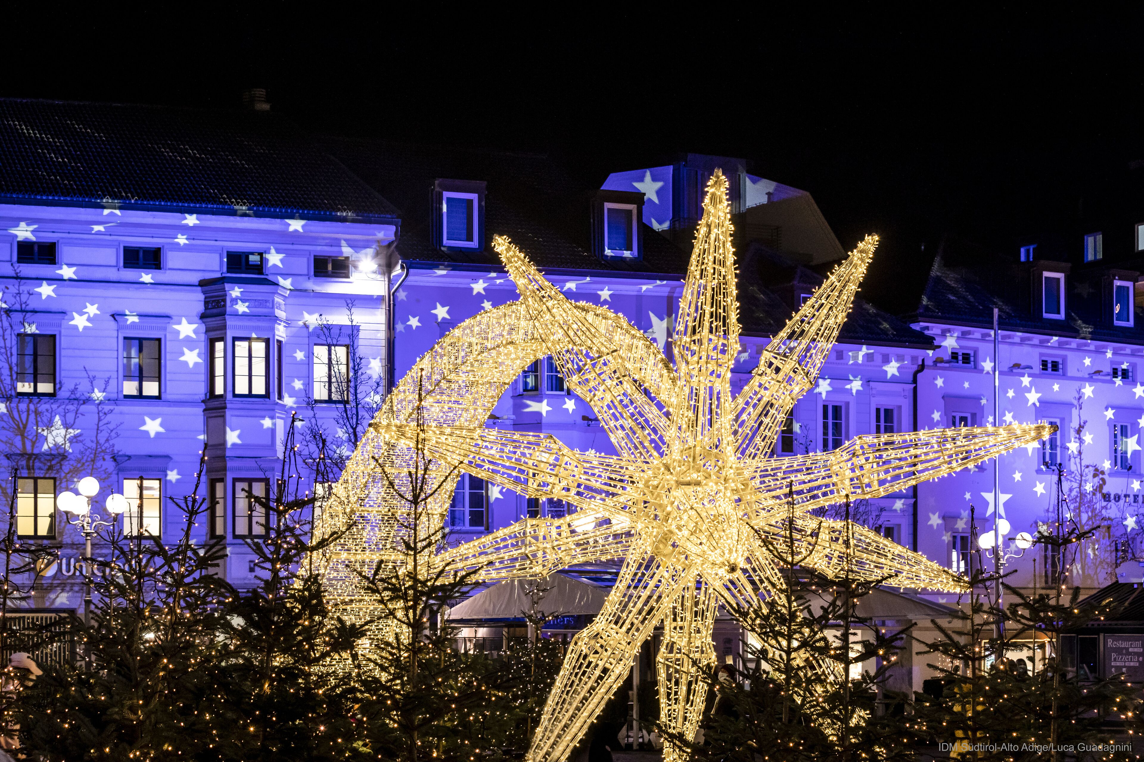 A building with a star-shaped light installation in front.