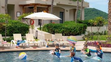 Relax by the pool surrounded by lush greenery and enjoy the views from the adjacent balcony.