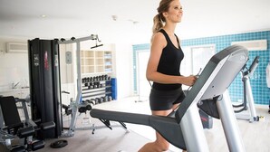 A gym with exercise equipment, a treadmill, and weights.