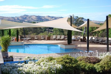 Piscine extérieure, parasols de plage, chaises longues