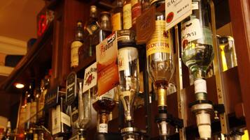 A bar with various liquor bottles and taps.