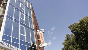 A hotel with a modern glass facade and a sign indicating it is a hotel and restaurant. - Hotel Kaiserhof (Wesel)