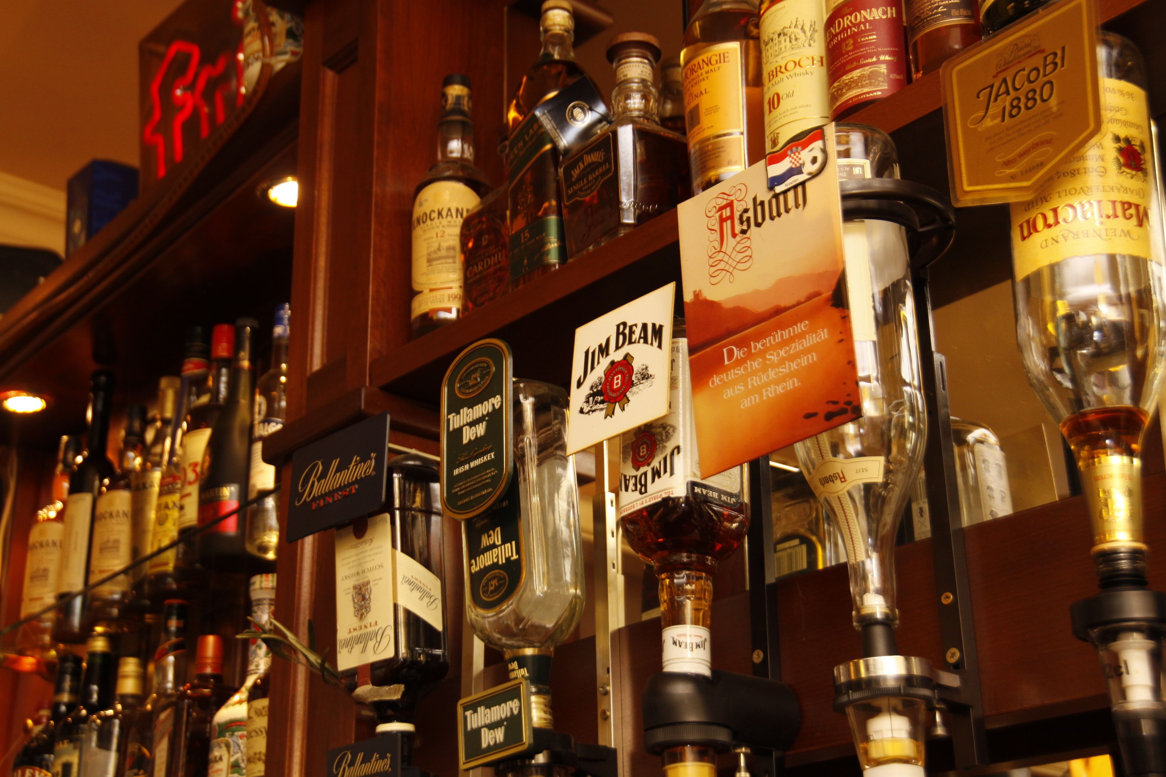 Un bar con varias botellas de licores y una selección de grifos de cerveza.