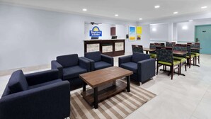 A hotel lobby with a reception desk, seating area, and a sign for 'Days Inn & Suites'. - Days Inn & Suites by Wyndham Siler City (Siler City)