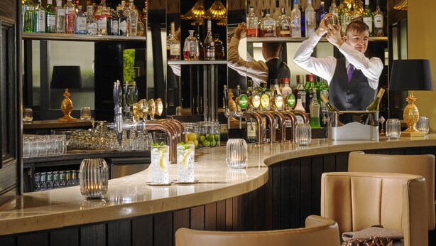 Un espace bar avec de nombreuses bouteilles d’alcool, une variété de verres et un comptoir.