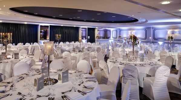 A banquet hall with round tables, white tablecloths, and chairs with white covers. - Kilkenny Ormonde Hotel (Kilkenny)