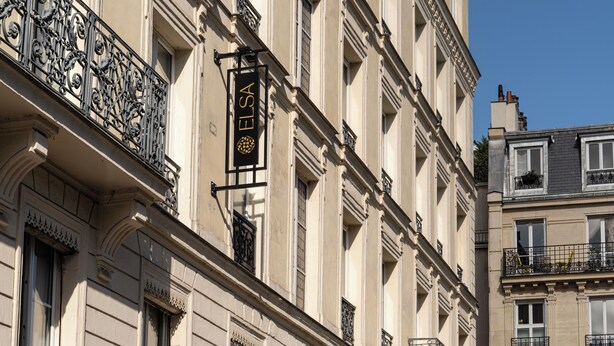 Un edificio con un letrero que dice 'ELSA' y balcones de hierro forjado ornamentados.