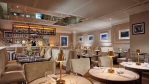 Un restaurant haut de gamme doté de plusieurs espaces de restauration, d’un bar et d’un intérieur bien éclairé.