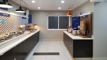 Una cocina moderna con barra desayunadora, área de panadería y exhibición de cereales.