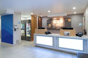A hotel reception area with a counter, a refrigerator stocked with beverages, and a sign indicating the market is open 24 hours. - Holiday Inn Express Santa Rosa North by IHG (Santa Rosa)