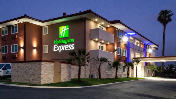 A Holiday Inn Express building with a stone facade, multiple balconies, and a parking lot. - Holiday Inn Express Santa Rosa North by IHG (Santa Rosa)