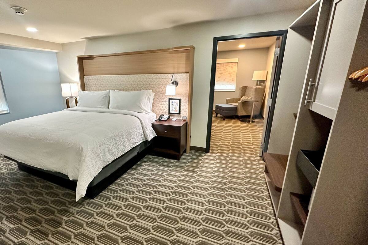 Een hotelkamer met een bed, nachtkastjes, een bureau en een stoel.