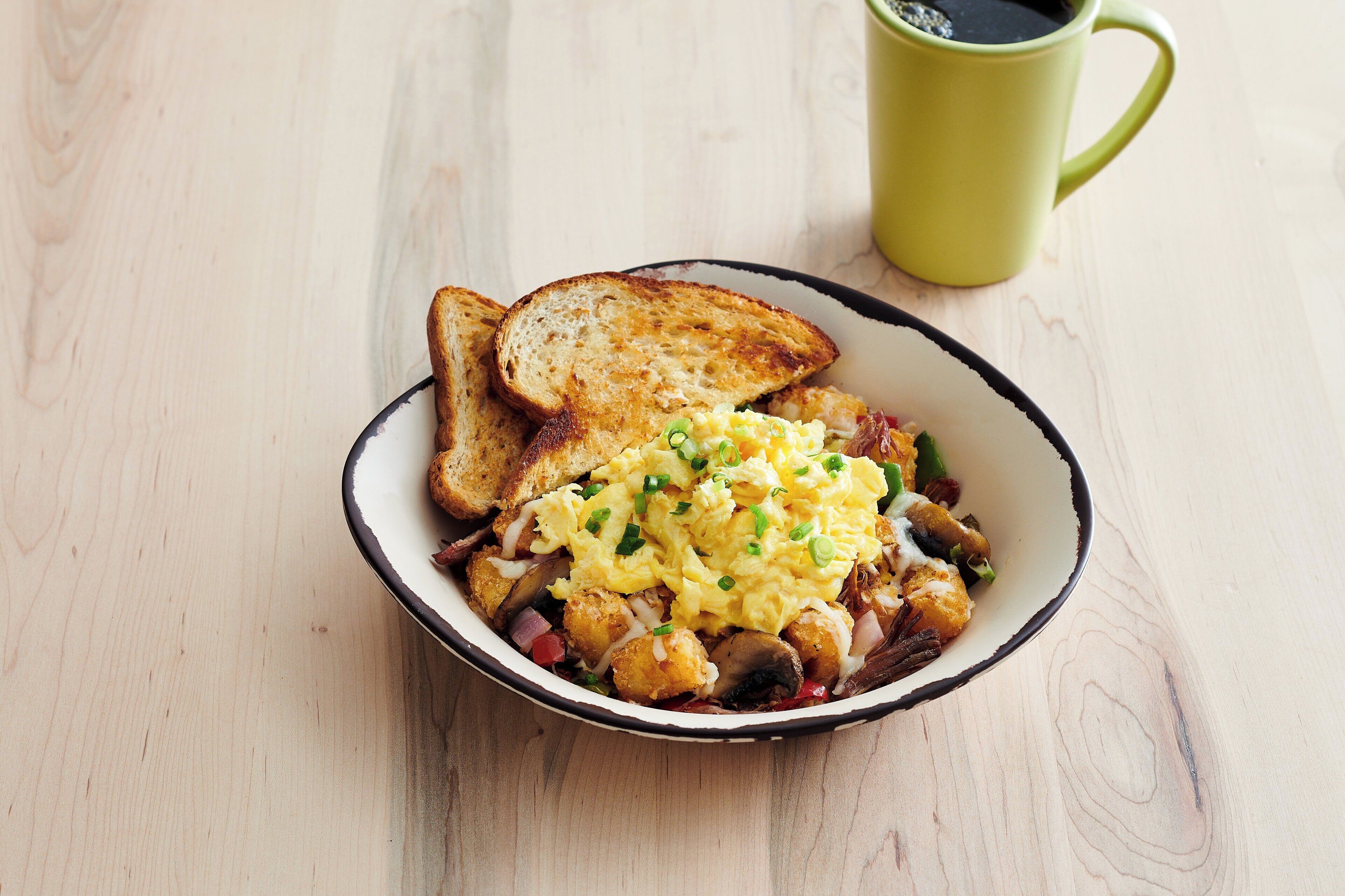 Un plato de comida con tostadas y huevos revueltos sobre una mesa de madera.