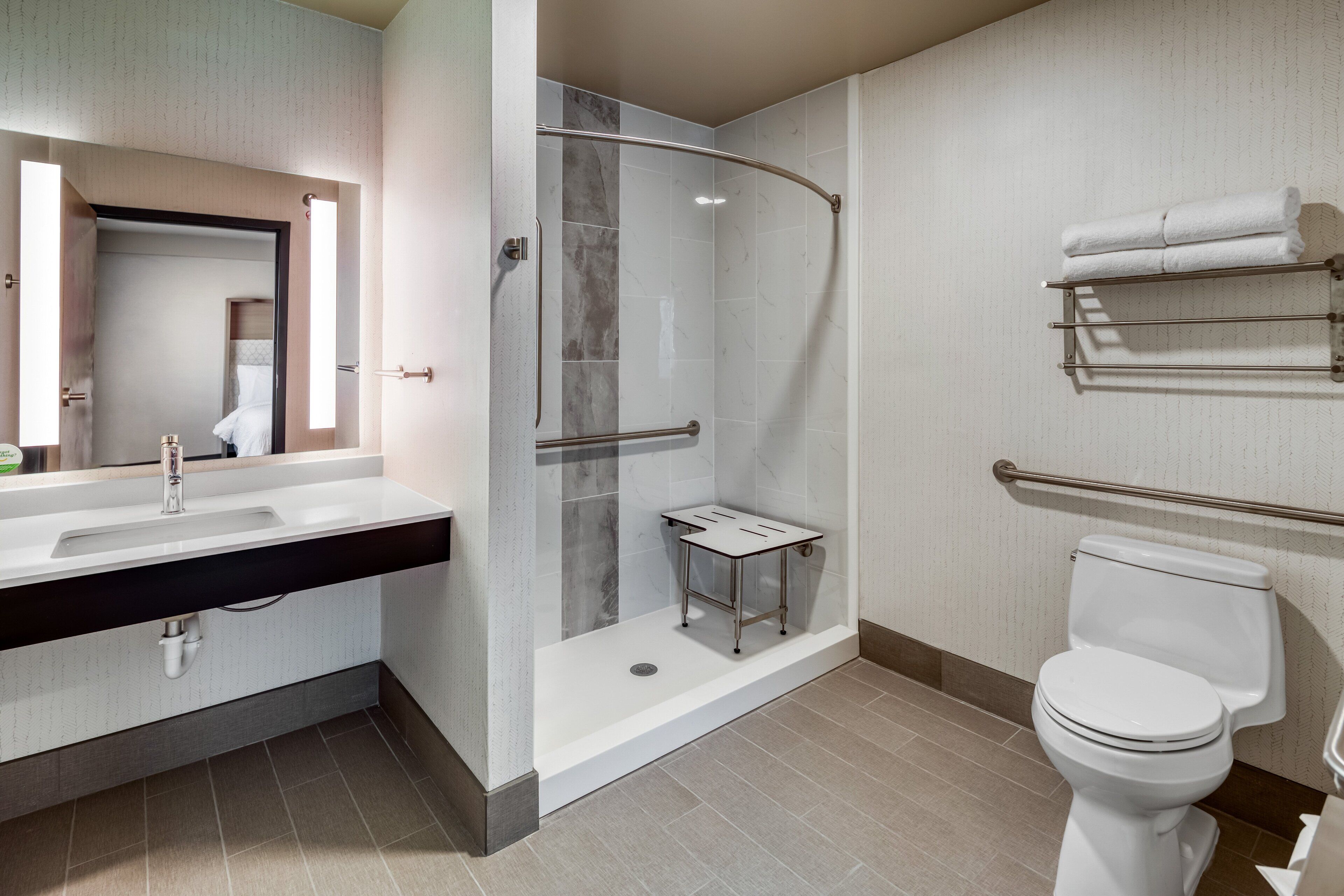 A modern bathroom with a shower, toilet, and vanity.