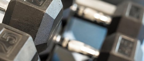 A close-up of a set of hexagonal dumbbells with weight markings.