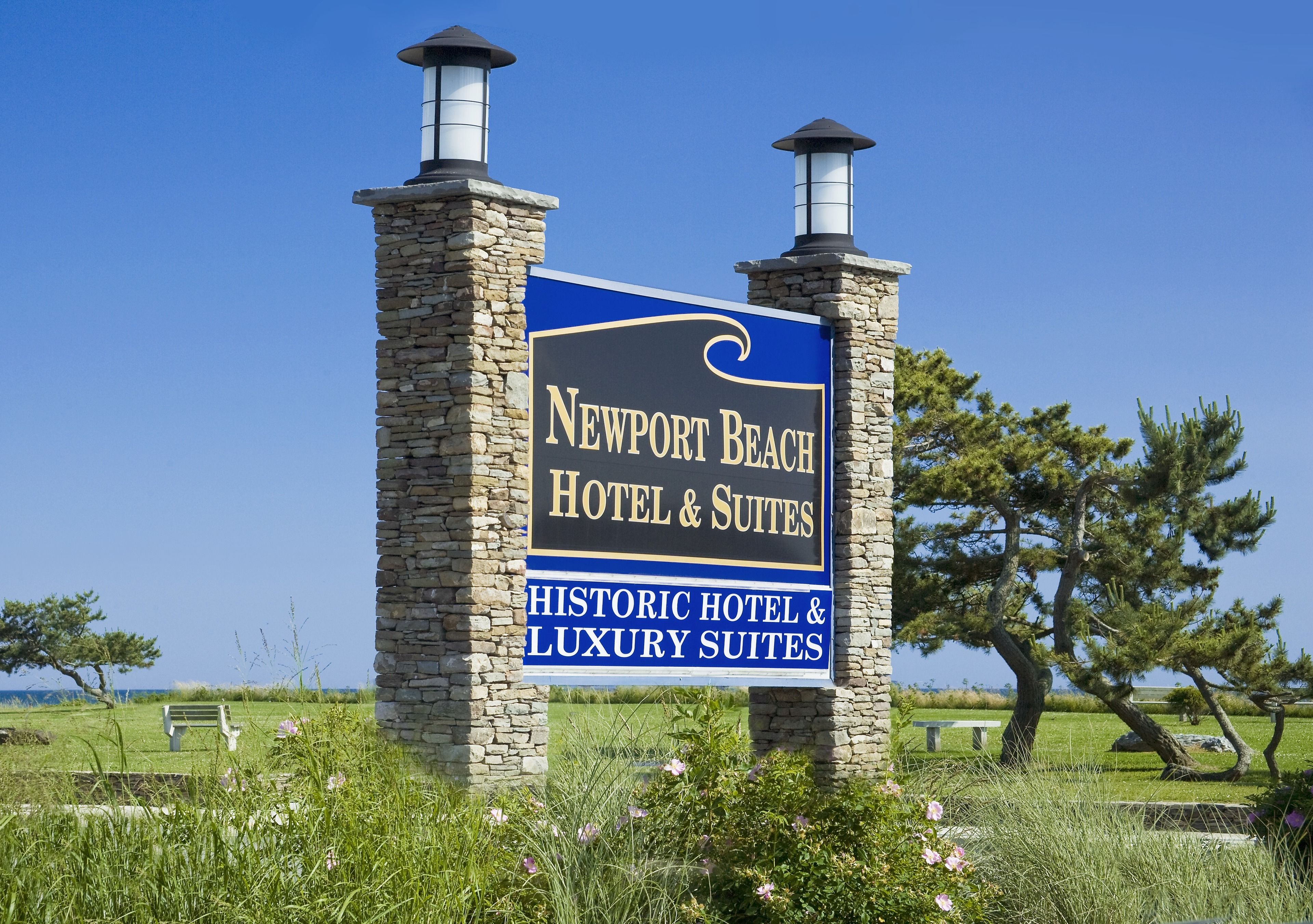 A sign for Newport Beach Hotel & Suites, indicating it is a historic hotel with luxury suites.