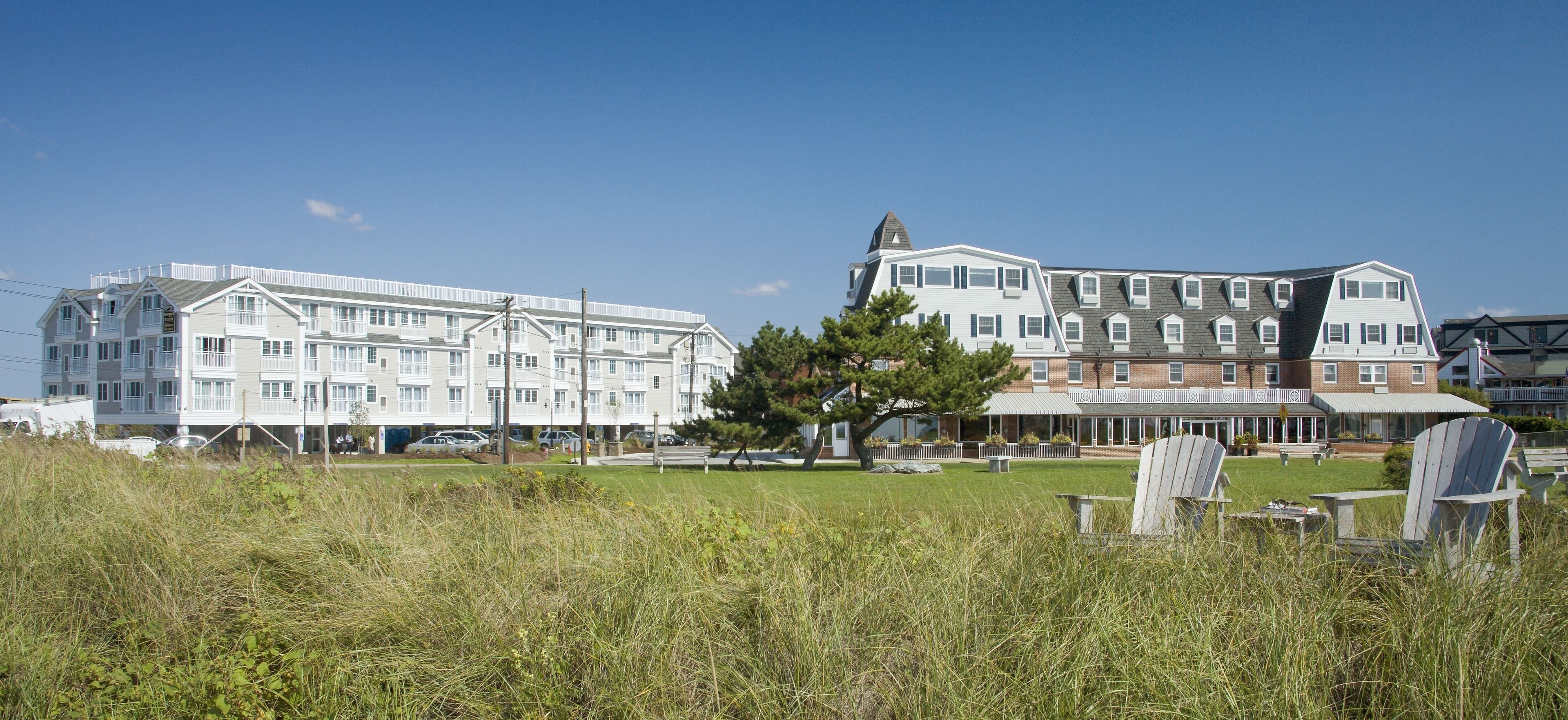 A hotel with multiple buildings, a grassy lawn, and outdoor seating.