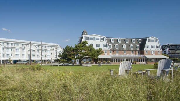 Un hotel con varias edificaciones, un césped y mesas al aire libre.