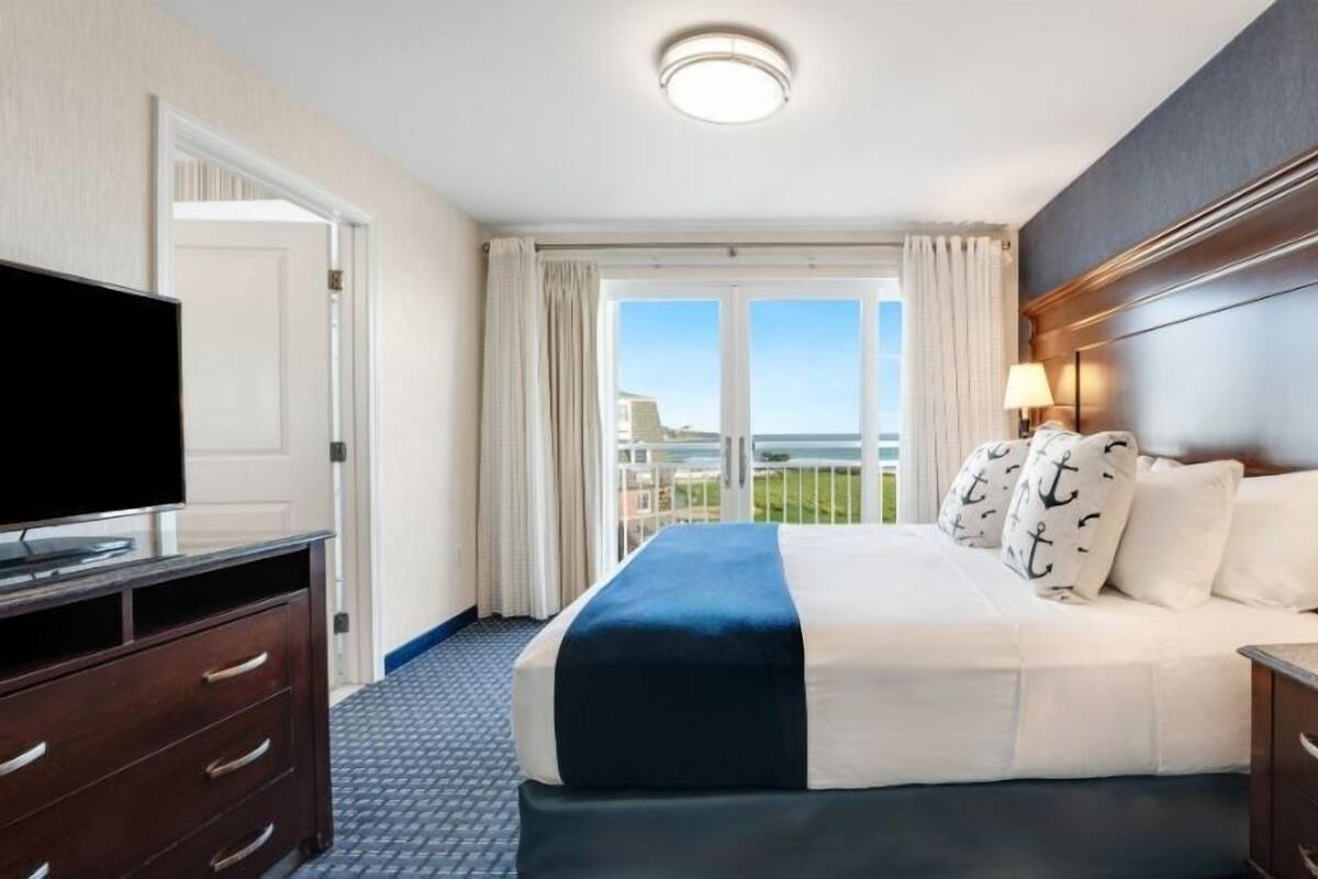 Une chambre d’hôtel avec un grand lit, une télévision, un bureau et une vue sur l’extérieur.