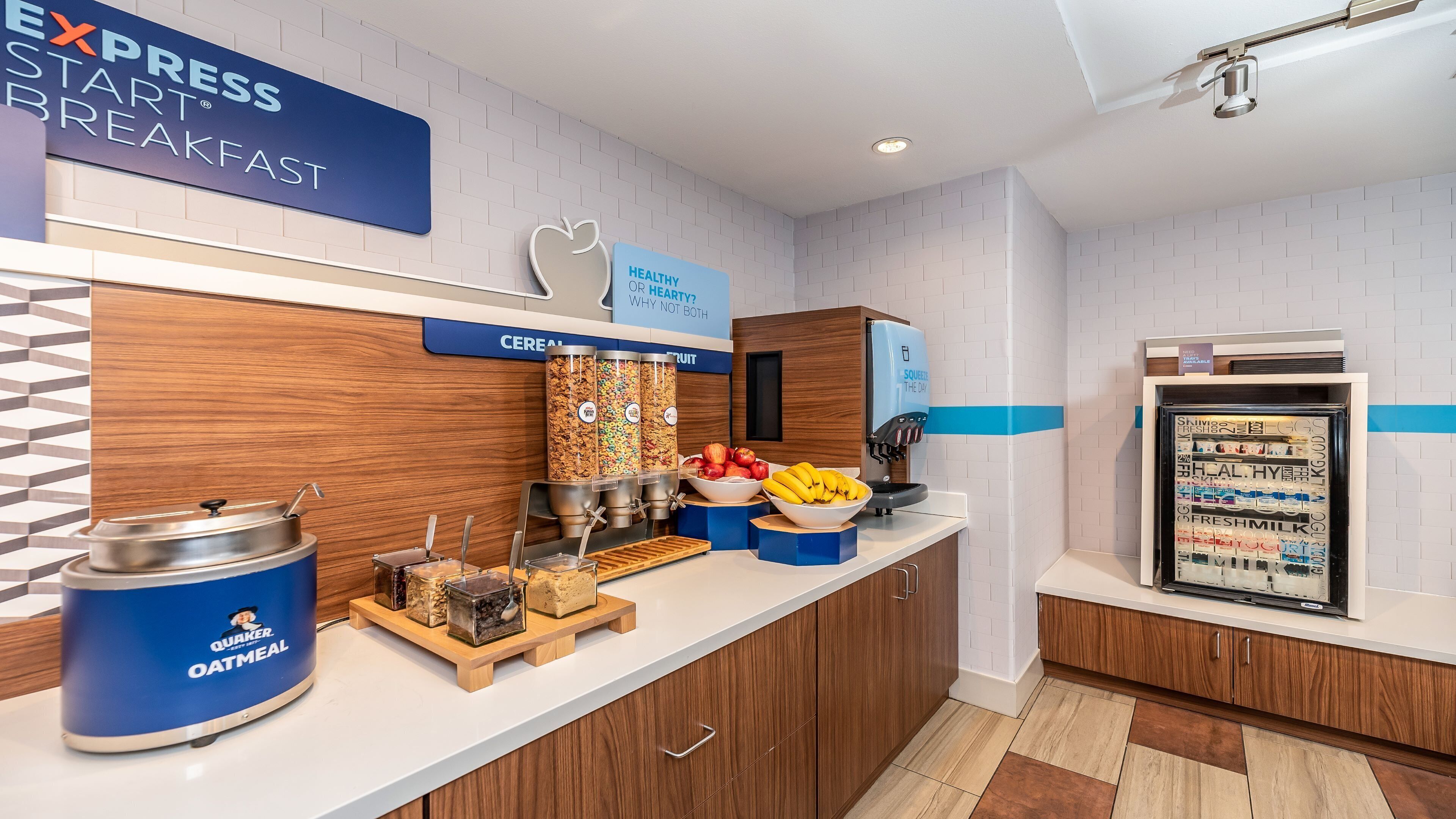 A breakfast area with Quaker Oatmeal, cereal, and fruit options.