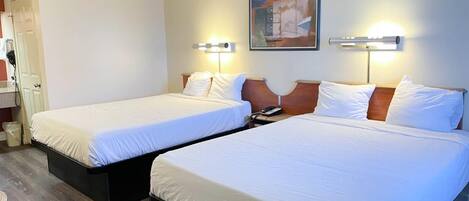 Habitación de hotel con dos camas, un cuadro en la pared y un teléfono en la mesita de noche.