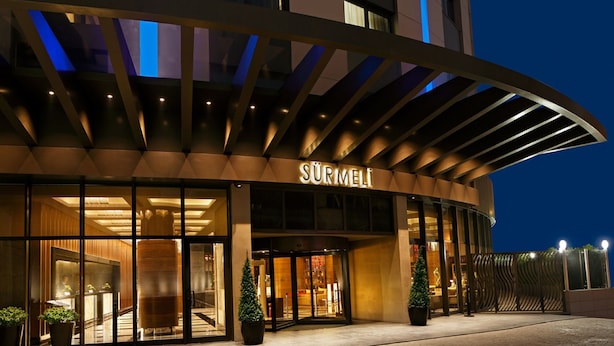 A hotel entrance with a modern design, featuring a curved roof and glass doors. - Surmeli Istanbul Hotel (Istanbul)