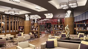A modern lounge area with sofas, armchairs, and a coffee table, featuring a patterned rug and a central decorative sculpture. - Surmeli Istanbul Hotel (Istanbul)