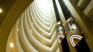 A multi-level atrium with a central spiral staircase, multiple floors, and a reception area. - Surmeli Istanbul Hotel (Istanbul)