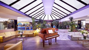 A spacious lobby with a grand piano, plush seating, and a high ceiling with skylights. - Gunes Hotel Merter (Istanbul)
