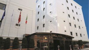 A hotel with a prominent entrance, multiple windows, and flags. - Gunes Hotel Merter (Istanbul)