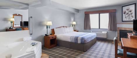 A hotel room with a large bed, a separate bathroom with a bathtub, a desk with a chair, and a television.