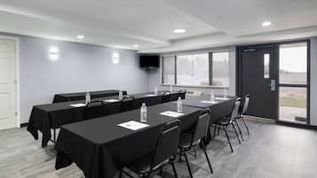 Una sala conferenze con un lungo tavolo, sedie e una porta che dà su una zona esterna.