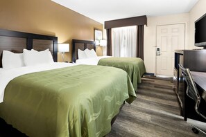 A hotel room with two beds, a desk, a TV, and a door. - Quality Inn Decatur River City (Decatur)